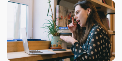 Woman using sign language in front of laptop screen